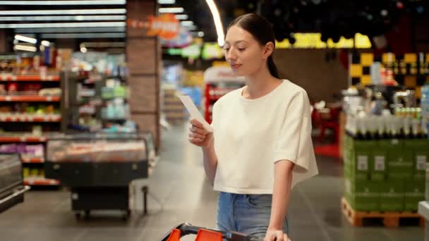 Vrouw Kijkt Geschokt Naar Een Papieren Cheque Een Supermarkt Prijsverhoging — Stockvideo