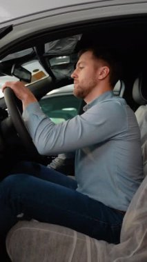 Bir adam satın almadan önce yeni elektrikli arabasını kontrol eder.