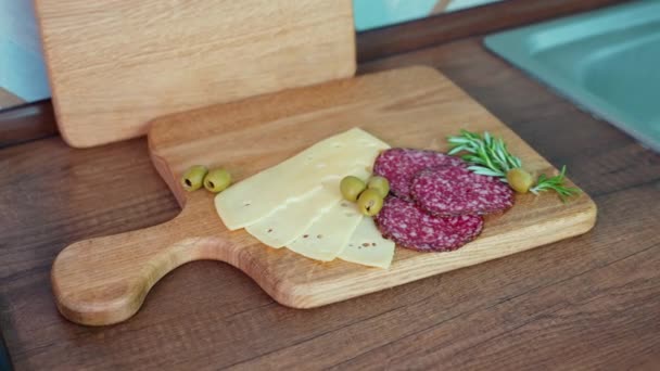 用腊肠 奶酪和橄榄在厨房切木板 从上方看 — 图库视频影像