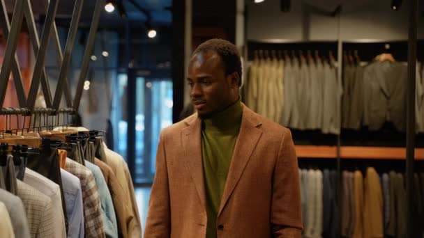 一个男人在商店里买新衣服 英俊的黑人男子走进服装店 — 图库视频影像