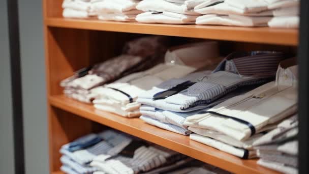 Prateleiras Com Monte Camisas Coloridas Dobradas Ordenadamente Nas Roupas Loja — Vídeo de Stock