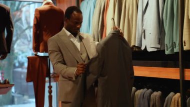 Yakışıklı Afro-Amerikan erkeği klasik takım elbise seçiyor..
