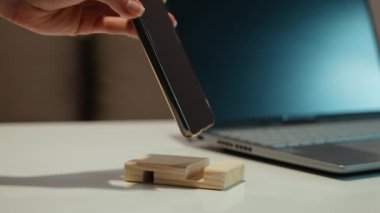 Kadın eli telefonu kürsüye koyar.