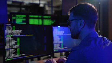 Programlama. Bilgisayarda çalışan, masa başında oturmuş kod yazan bir adam. Programcı Veri Kodu Yazıyor, Yazılım Geliştirme Şirketinde Proje Üzerinde Çalışıyor