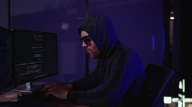 Tehlikeli kukuletalı Hacker hükümet veri sunucuları keser ve bir virüs ile onların sistemi bozar. Onun saklanma yerine karanlık atmosfer, birden çok ekran, kabloları her yerde vardır.