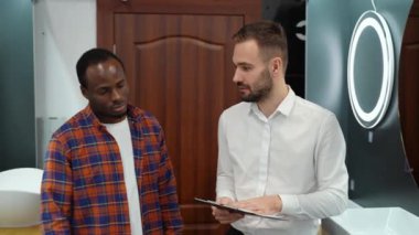 Genç Afrikalı Amerikalı bir adam yeni tuvalet mobilyalarını seçiyor.