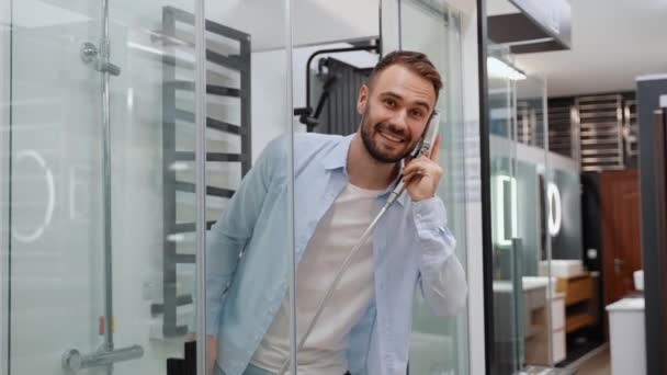 Zabawny Człowiek Kupujący Naśladuje Rozmowę Telefoniczną Kabinie Prysznicowej Sklepie Hydraulicznym — Wideo stockowe