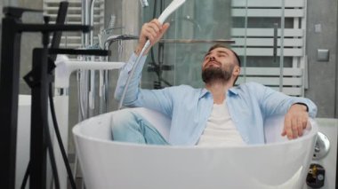 Komik adam, tesisat dükkanında banyo yapıyormuş gibi yapıyor..