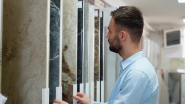 Yakışıklı bir adam evdeki seramik fayansları seçiyor..