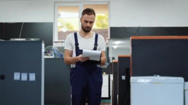 Erkek işçi, pazarlamacı, mağazada seramik klozet envanteri çıkarıyor.