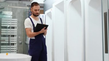 Üniformalı satıcı mağazadaki hamamların envanterini çıkarıyor..