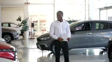 Araba satışı galeride. Araba galerisindeki siyah satıcı.