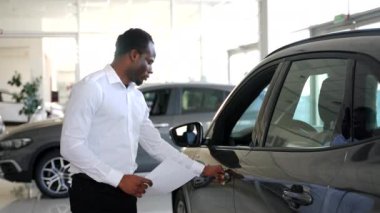 Araba satışı galeride. Araba galerisindeki siyah satıcı.