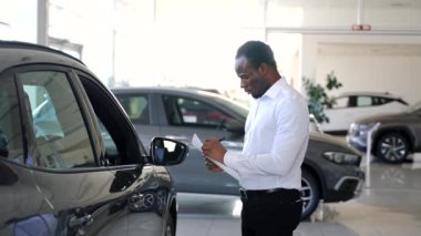 Araba satışı galeride. Araba galerisindeki siyah satıcı.