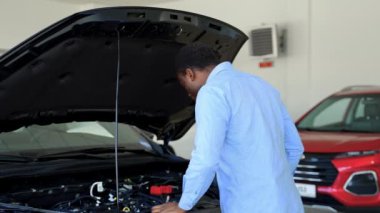 Afro-Amerikalı bir adam araba galerisinden yeni bir araba alıyor.