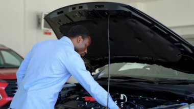 Afro-Amerikalı bir adam araba galerisinden yeni bir araba alıyor.