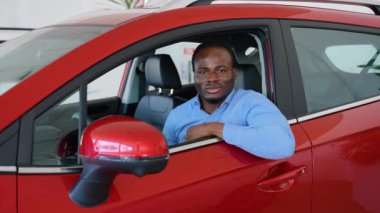 Afro-Amerikalı bir adam araba galerisinden yeni bir araba alıyor.