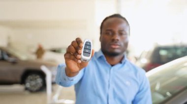 Afro-Amerikalı bir adam araba galerisinden yeni bir araba alıyor.