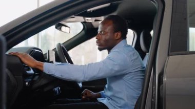 Afro-Amerikalı bir adam araba galerisinden yeni bir araba alıyor.