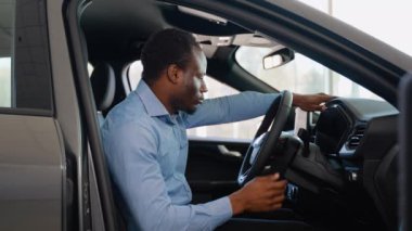 Afro-Amerikalı bir adam araba galerisinden yeni bir araba alıyor.