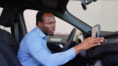 Afro-Amerikalı bir adam araba galerisinden yeni bir araba alıyor.