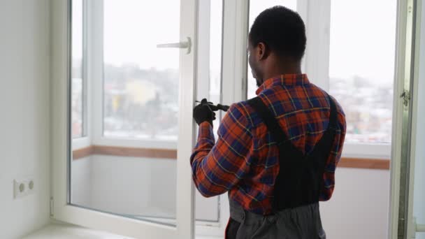 Афроамериканський Працівник Встановлює Вікно Пвх Приміщенні — стокове відео