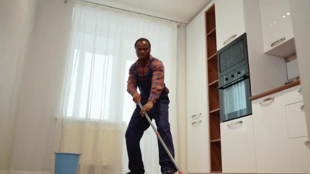 Zabawny Czarny Wesoły Profesjonalny Sprzątaczka Tańczy Mopem Podczas Mycia Podłogi — Wideo stockowe