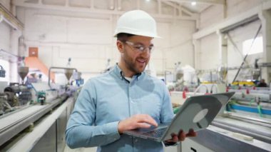 Dizüstü bilgisayarlı baş mühendis üretim sürecini analiz ediyor.