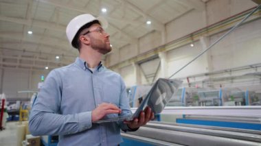 PVC Windows Fabrikası 'nda dizüstü bilgisayarı olan baş mühendis üretim sürecini analiz ediyor