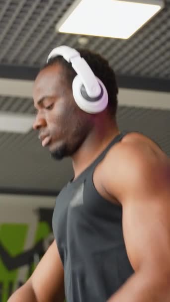 Ein Mann Mit Kopfhörern Läuft Einem Modernen Fitnessstudio Auf Einem — Stockvideo