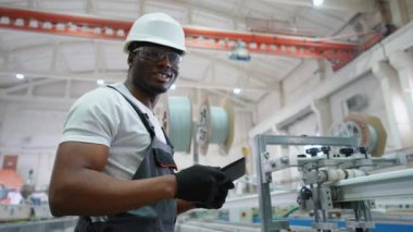 Üretim hattında tableti olan PVC fabrika mühendisi portresi.