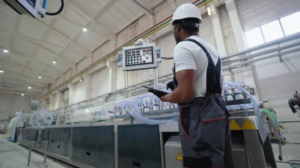 穿着硬帽和制服的工厂工人正在使用带有工程技术软件的平板电脑 — 图库视频影像