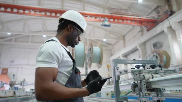 Pvcの工場労働者エンジニアは生産ラインの工学ソフトウェアが付いているタブレットを使用しています — ストック動画