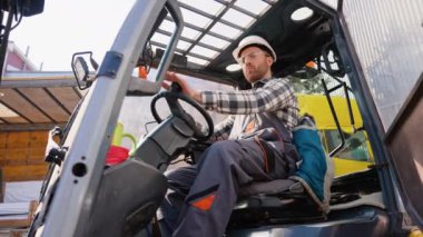 Depo işçisi forklift yükleyicisi kullanıyor..