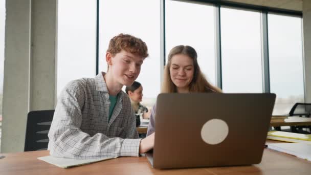 两个学生在教室的课桌边一起使用笔记本电脑 — 图库视频影像
