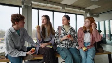 Lise öğrencileri öğle yemeğinde elma yiyor..