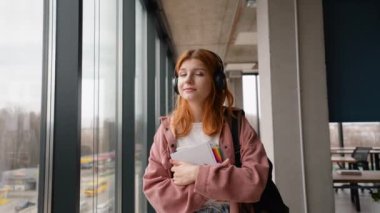 Üniversitede kitap ve çantayla yürüyorum.