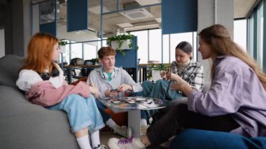 Mutlu duygusal genç öğrenciler kampüste boş zaman geçirip heyecan verici masa oyunları oynuyorlar..