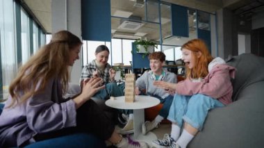 Kafe masasında oturup masa oyunları oynayan neşeli gençlerin portresi..