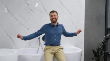 Tesisatçı dükkanındaki yeni hamamının yanında yakışıklı bir adam..