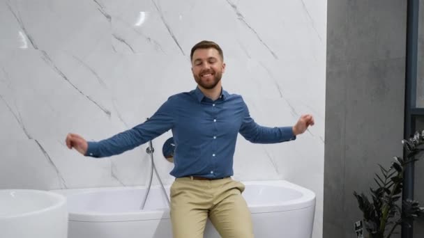 配管店で新しいお風呂の近くにハンサムな男 — ストック動画
