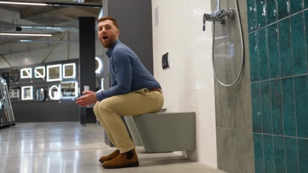 Homme Drôle Est Assis Sur Les Toilettes Dans Magasin Regarde — Video