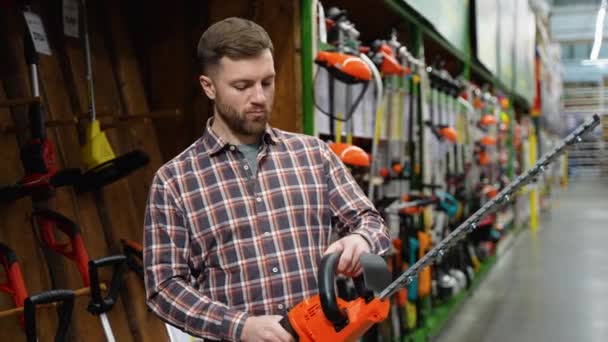 Man Hardware Store Chooses New Electric Hedge Trimmer — Stock Video