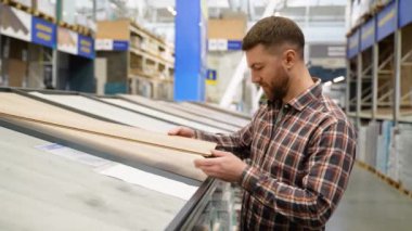 Dükkanda ahşap döşemeyi seçen bir adam..