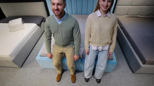 一个男人和一个女人躺在家具店的床上测试床垫上 — 图库视频影像