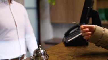Misafir otel lobisindeki resepsiyonistin anahtarlarını veriyor. Otelden ayrılın..