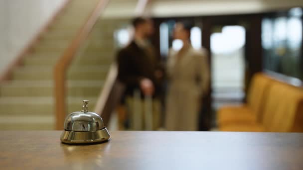 在酒店接待处附近交谈的年轻夫妇 有选择地关注服务铃 — 图库视频影像