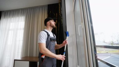 Evde pencereyi temizleyen bir adam..