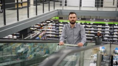 İnşaat mağazasında yürüyen merdivende tramvayı olan bir müşteri..