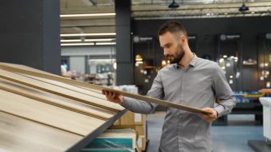 Döşeme mağazasındaki yeni ev için katları kaplayan bir adam..